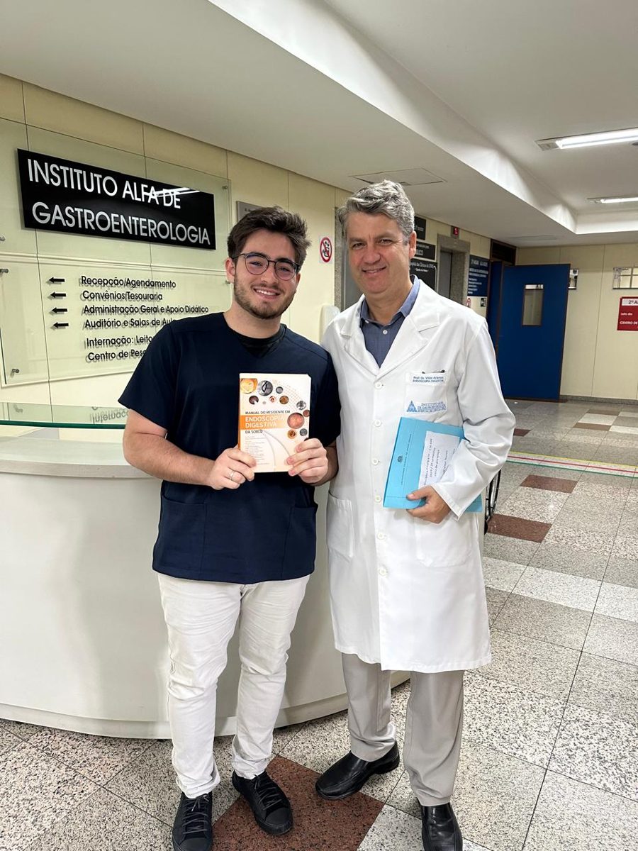 Lucas Delgado receiving the award from Prof. Vitor Arantes at the Instituto Alfa de Gastroenterologia, HC-UFMG